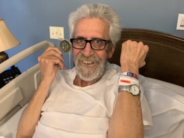 Navy Veteran Richard Ferguson shows off his challenge coin and WHV bracelet